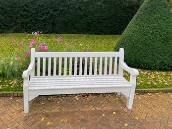 Photo of White wooden bench in autumn park on sunny day