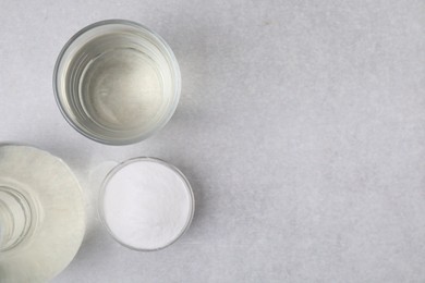 Photo of Vinegar and baking soda on light table, flat lay. Space for text