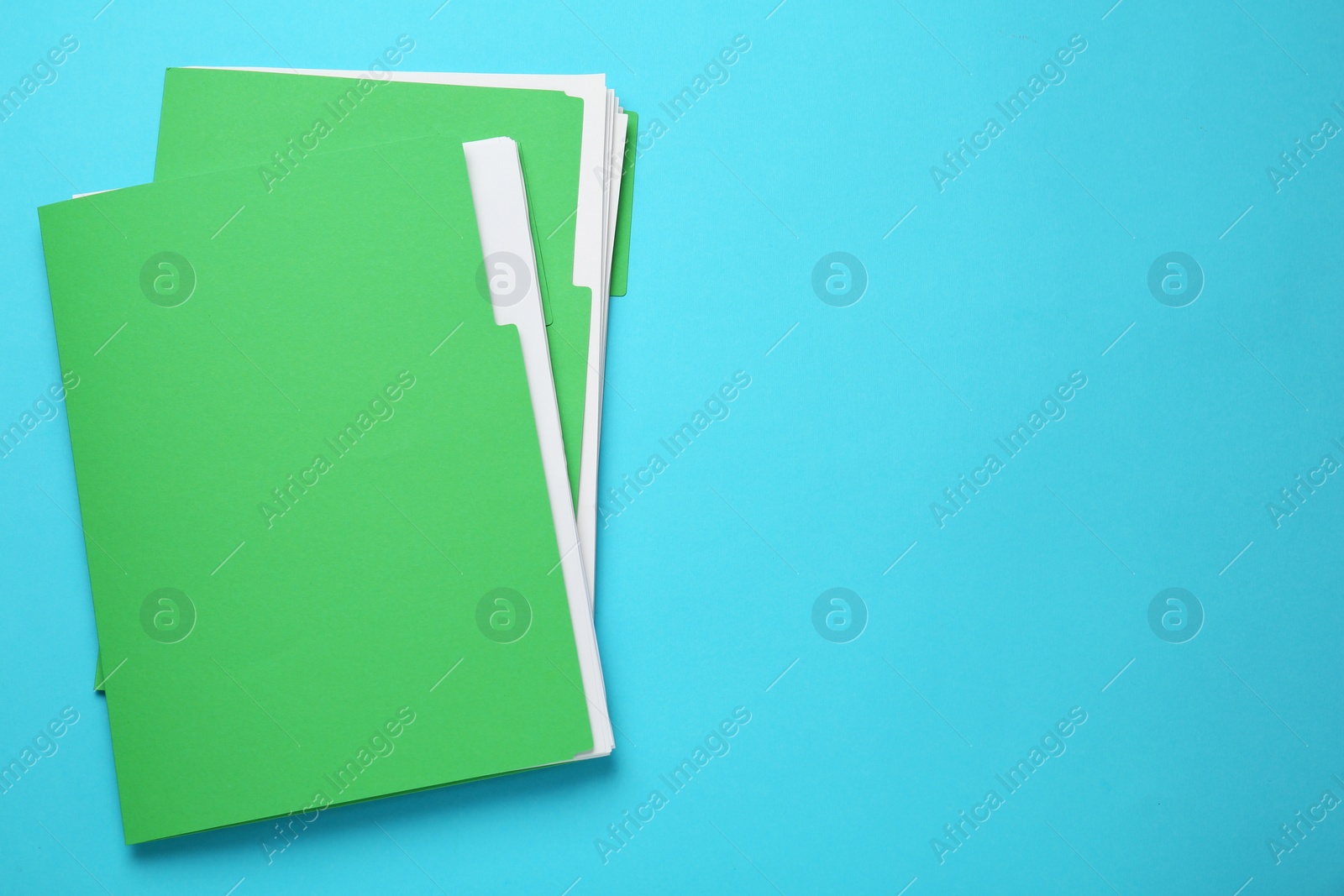 Photo of Light green files with documents on turquoise background, top view. Space for text