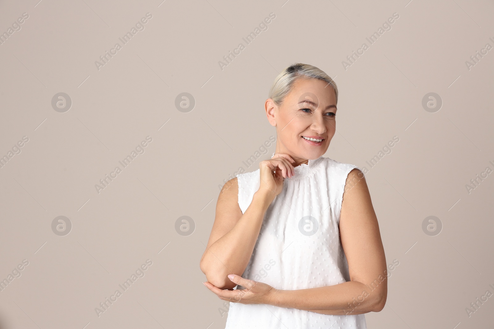 Photo of Portrait of beautiful mature woman on beige background. Space for text