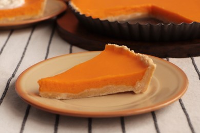 Photo of Plate with piece of fresh homemade pumpkin pie on table