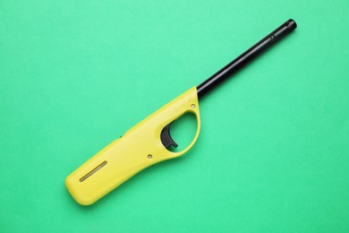 Photo of One gas lighter on green background, top view