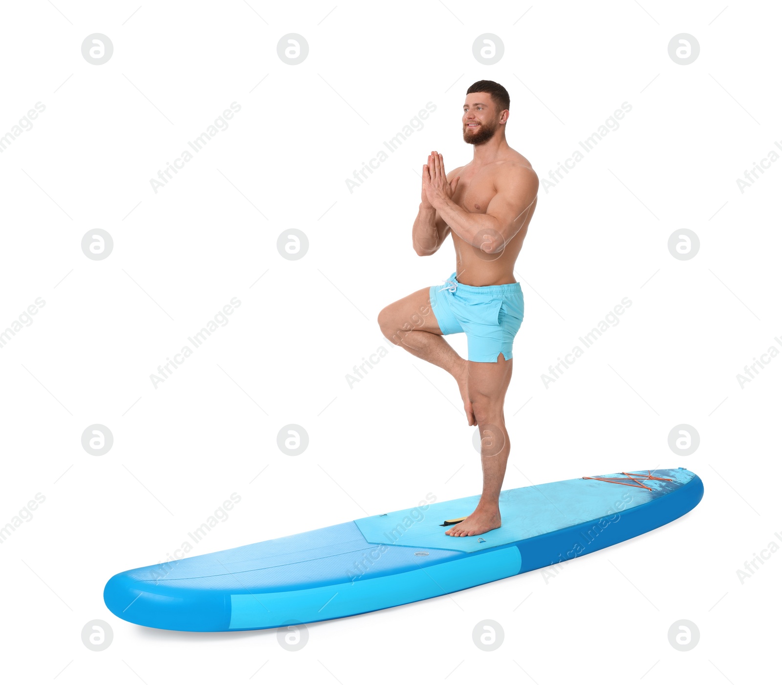 Photo of Happy man practicing yoga on blue SUP board against white background