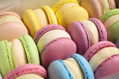 Many delicious colorful macarons as background, closeup