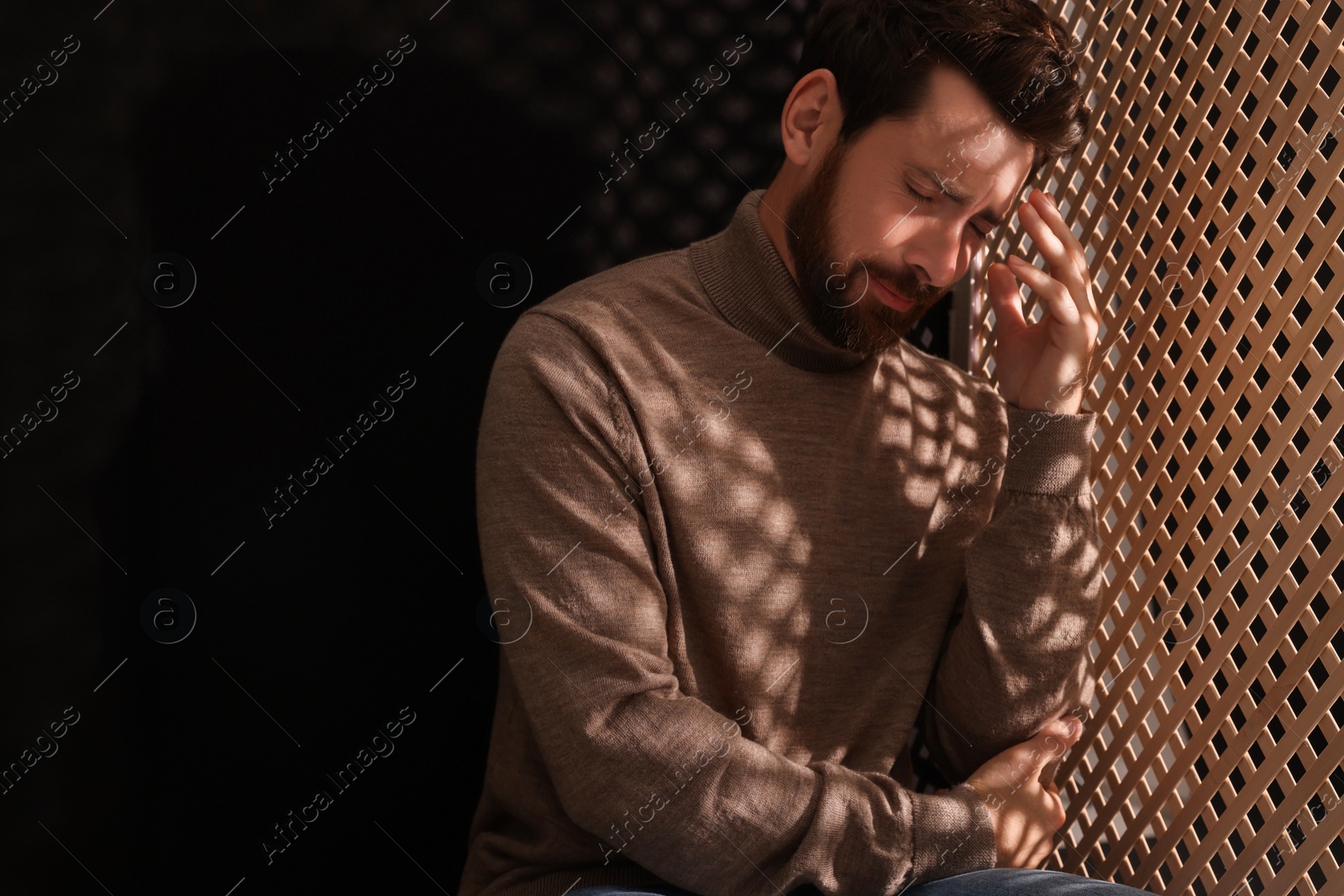 Photo of Upset man listening to priest during confession in booth, space for text