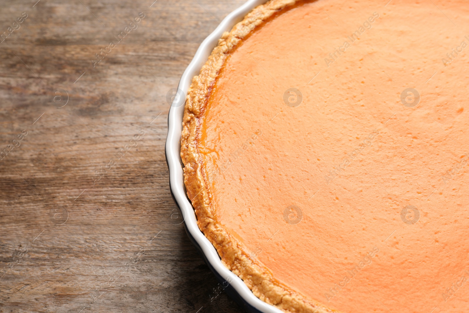 Photo of Fresh delicious homemade pumpkin pie on wooden background. Space for text