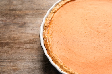 Fresh delicious homemade pumpkin pie on wooden background. Space for text