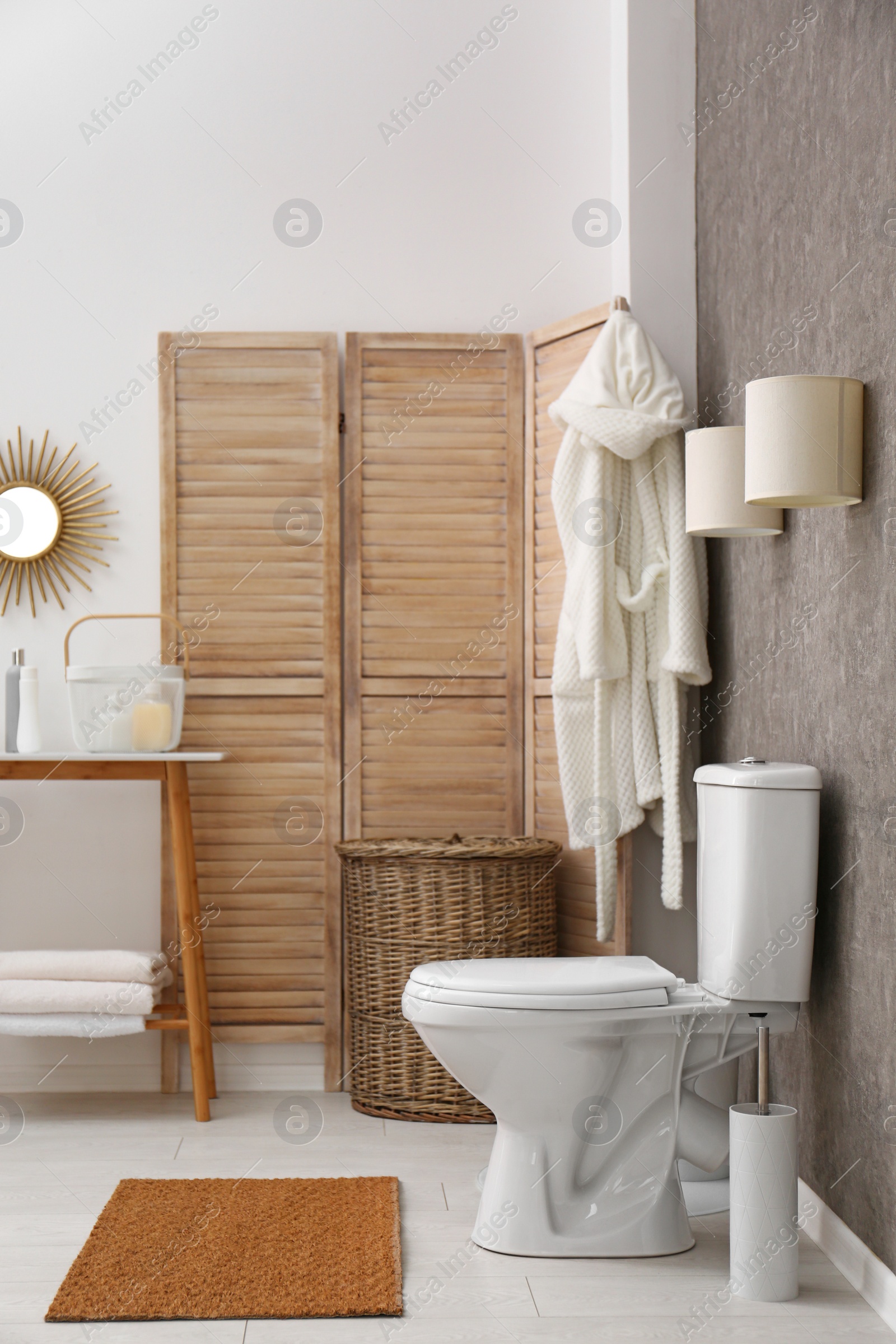 Photo of Ceramic toilet bowl in stylish bathroom. Idea for interior design