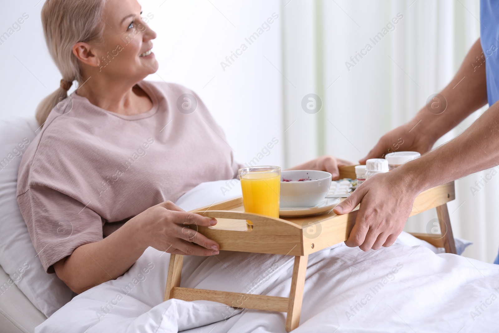 Photo of Male nurse bringing food and medicine for patient in hospital ward, closeup. Doctor's prescription