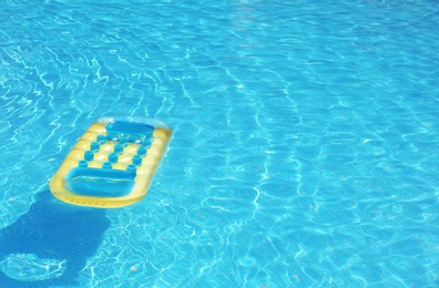 Photo of Inflatable mattress floating in pool on sunny day