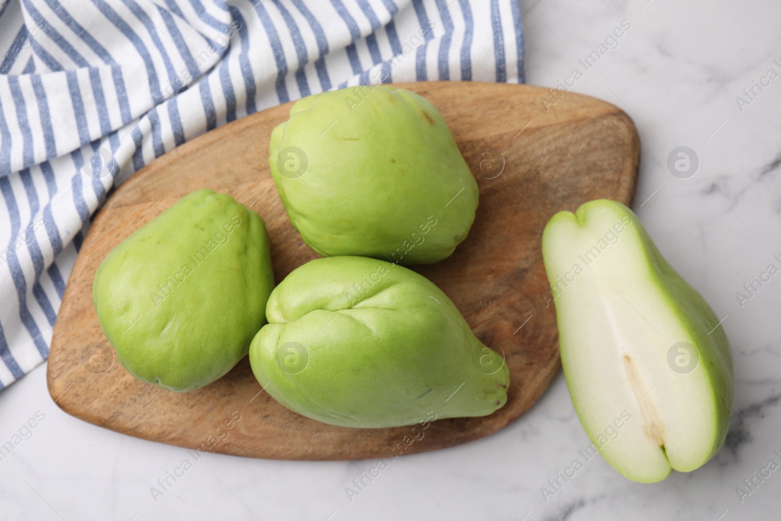 Photo of Fresh green chayote on light marble table, top view