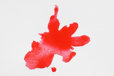 Photo of Blot of red ink on white background, top view