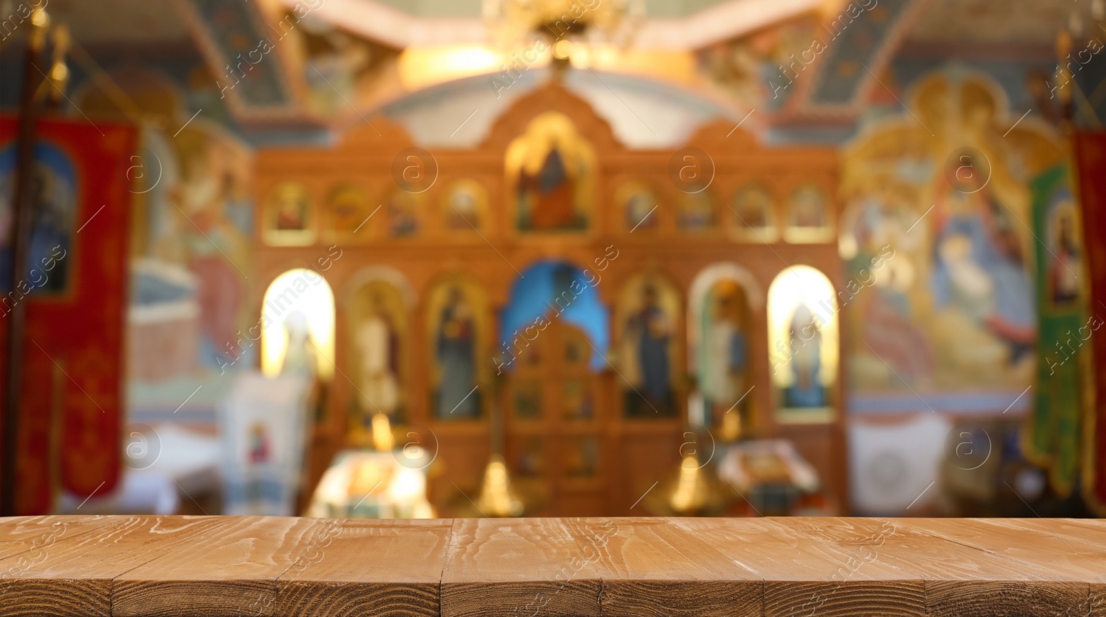 Image of Empty wooden table and blurred view of beautiful church interior, space for text