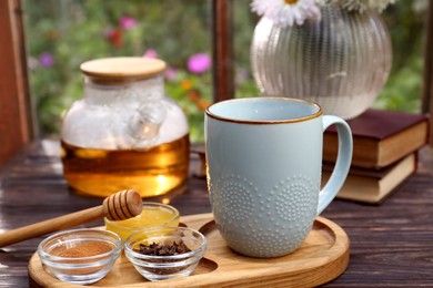 Photo of Tray with delicious tea and ingredients on wooden table, closeup