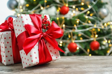 Photo of Beautiful gift boxes and blurred Christmas tree on background