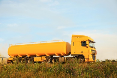 Photo of Modern yellow truck parked on country road