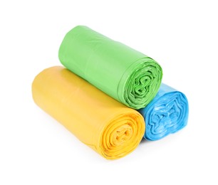 Photo of Rolls of colorful garbage bags isolated on white