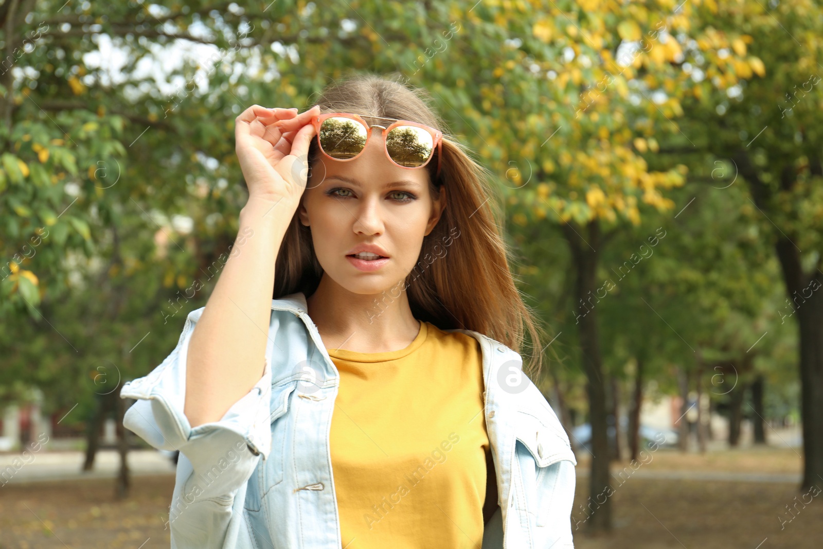 Photo of Young woman wearing stylish sunglasses in park