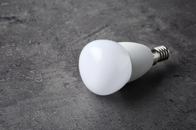 New modern lamp bulb on grey stone surface