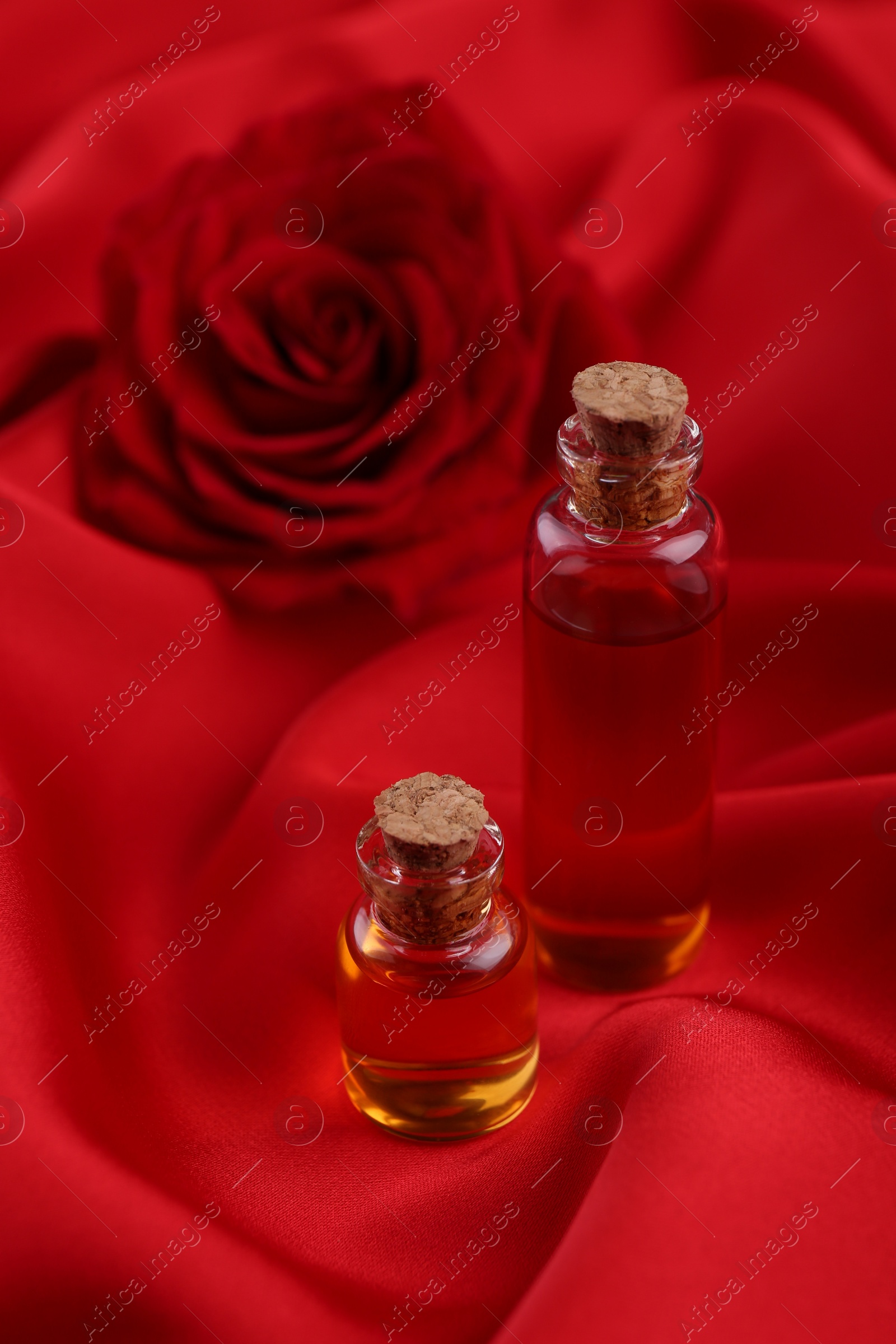 Photo of Bottles of love potion on red fabric