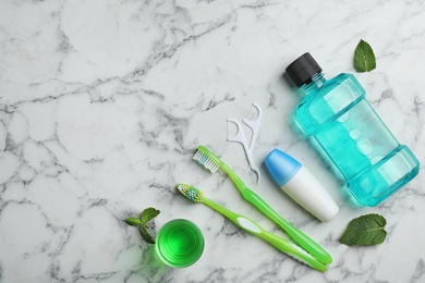 Flat lay composition with oral care products and space for text on marble background. Teeth hygiene