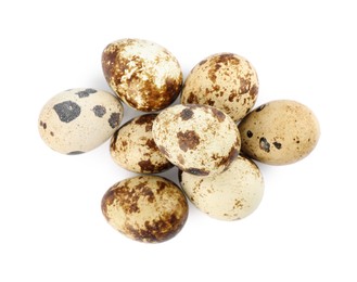 Photo of Many speckled quail eggs on white background, top view