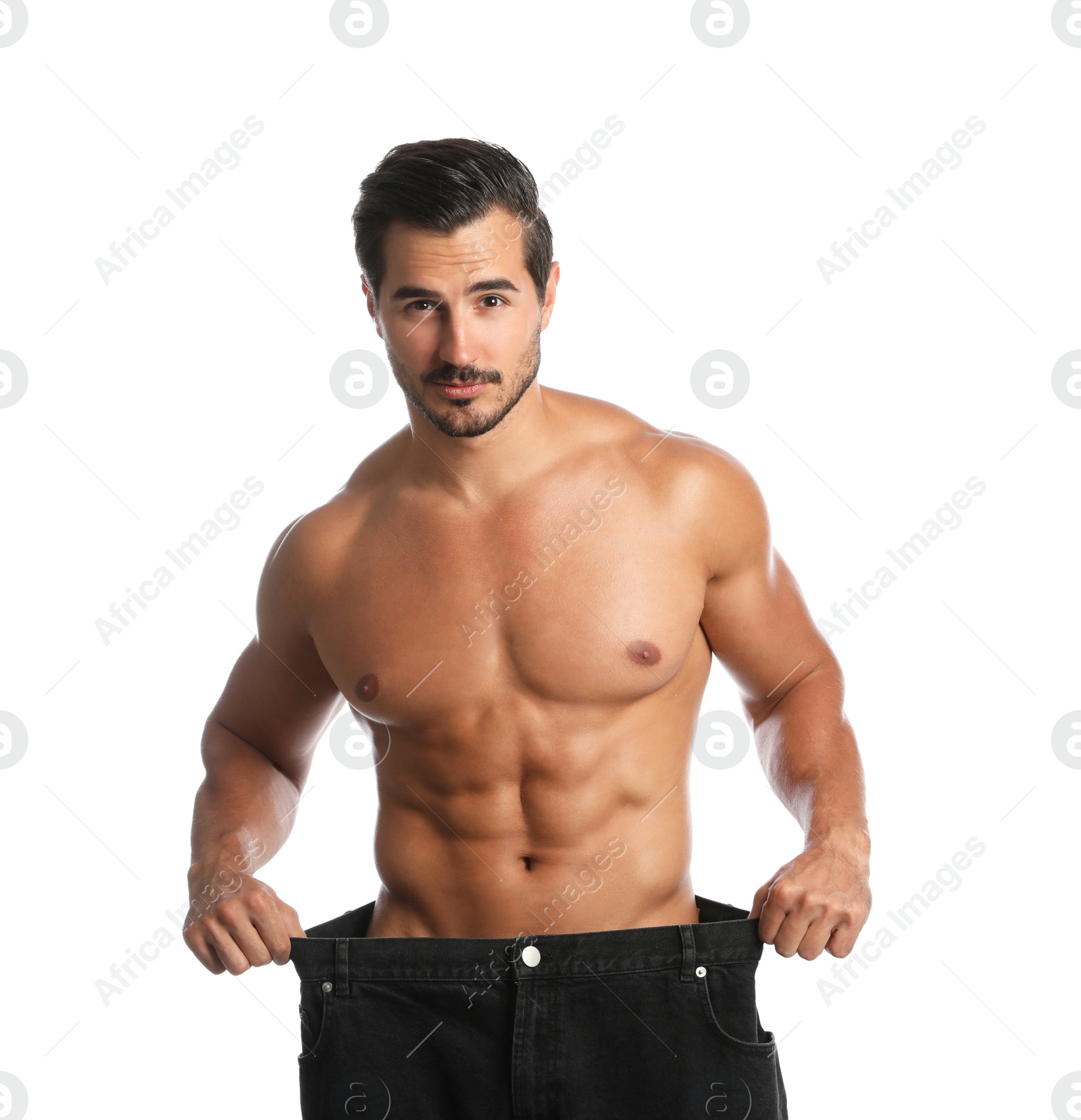 Photo of Young man with slim body in old big size jeans on white background