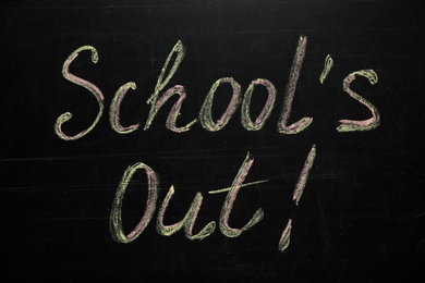 Photo of Text SCHOOL'S OUT written on blackboard. Summer holidays