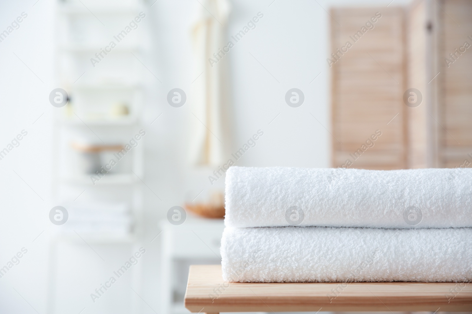 Photo of Stack of towels on table against blurred background