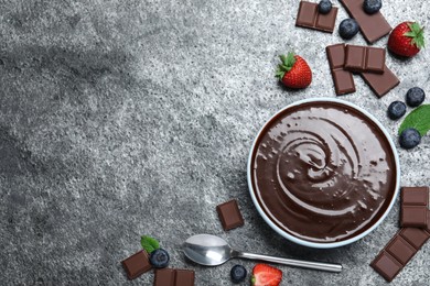 Photo of Delicious chocolate cream with berries and mint on grey table, flat lay. Space for text