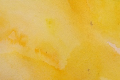 Abstract yellow watercolor painting as background, top view