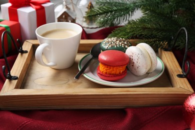 Photo of Different decorated Christmas macarons served with coffee on table