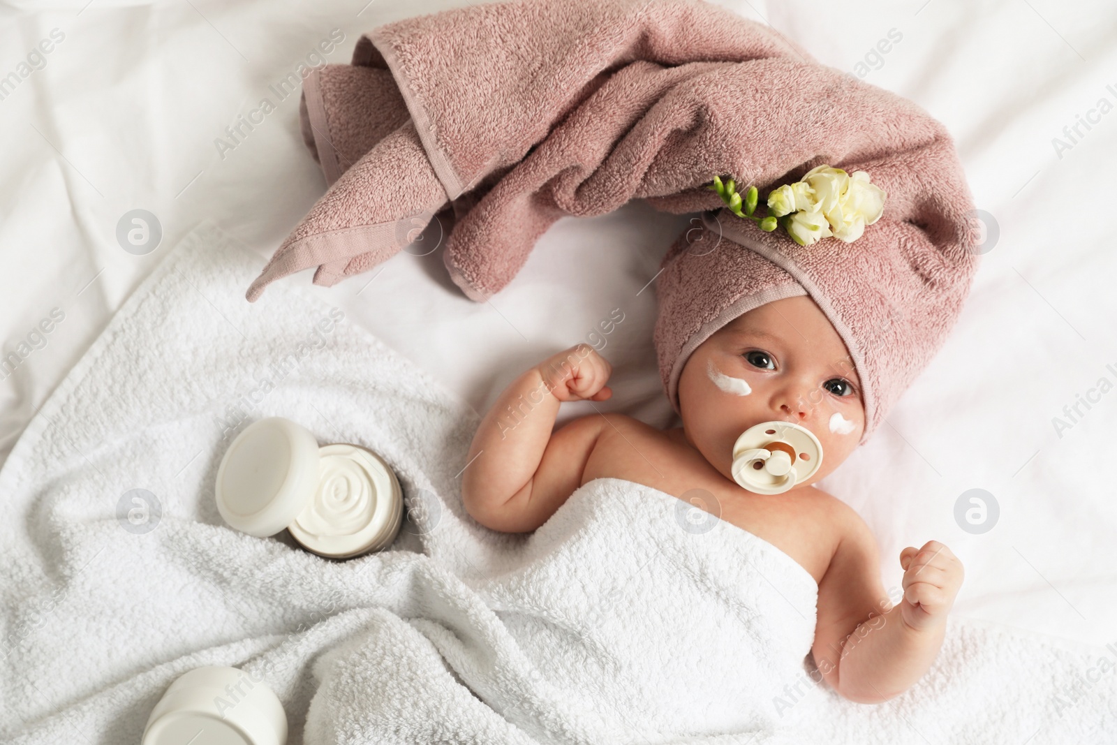 Photo of Cute little baby with cream on face, top view