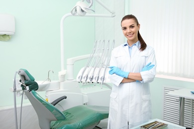 Photo of Young female dentist in white coat at workplace. Space for text