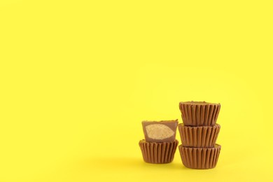 Sweet peanut butter cups on yellow background. Space for text