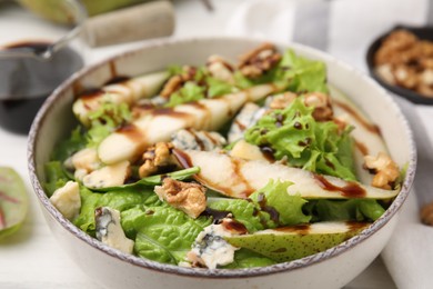 Photo of Delicious pear salad with sauce in bowl on table, closeup