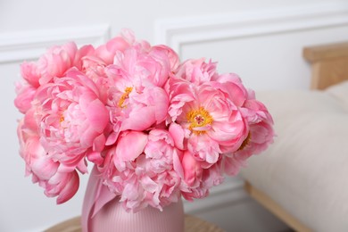 Photo of Beautiful bouquet of pink peonies in vase on wooden table indoors, closeup