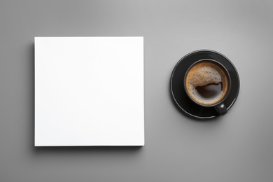 Blank paper sheets for brochure and cup of coffee on grey background, flat lay. Mock up