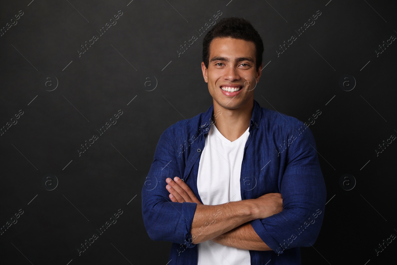 Photo of Handsome young African-American man on black background