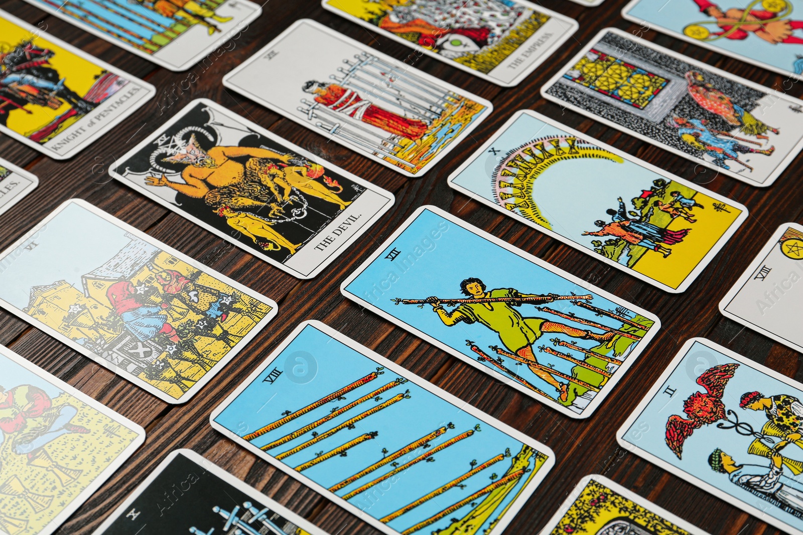 Photo of Many tarot cards on wooden table, closeup