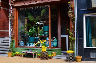 Store with different vintage decor elements and flowers, view from outside