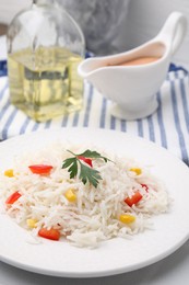 Photo of Plate of delicious rice with vegetables and parsley on table, closeup