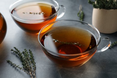 Photo of Aromatic herbal tea with thyme on grey table