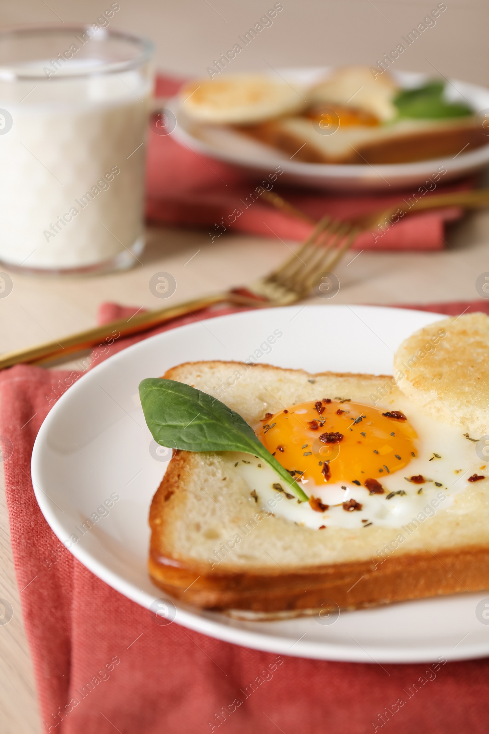Photo of Tasty toast with fried egg and spinach leaf on table, closeup