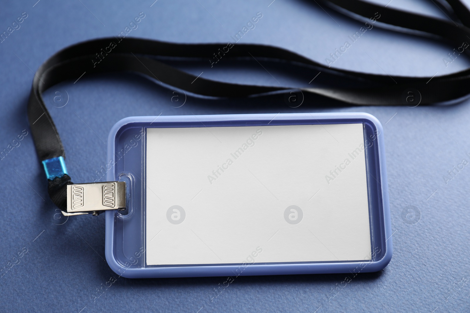 Photo of Blank badge with string on blue background, closeup