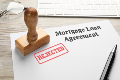 Image of Mortgage loan agreement with Approved stamp and pen on table, closeup