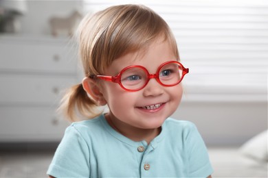 Photo of Cute little girl in glasses at home