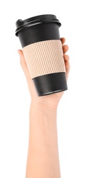 Woman holding takeaway paper coffee cup with cardboard sleeve on white background, closeup