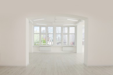 Photo of Empty office room with white walls, clean windows and modern lights on ceiling. Interior design
