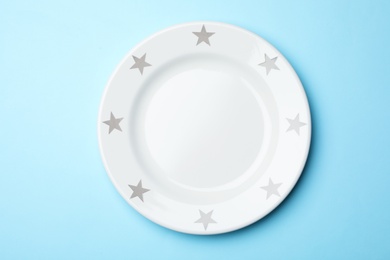 Stylish ceramic plate on color background, top view